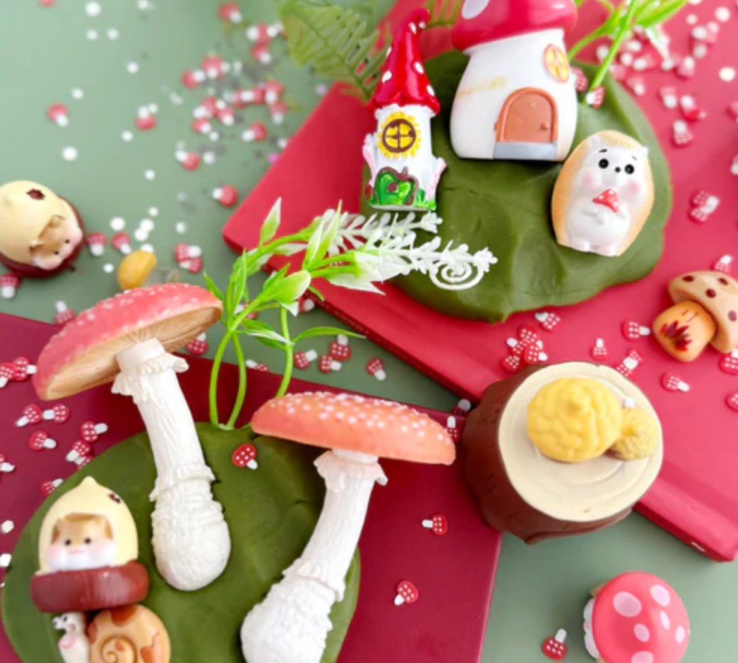 Decorative set of small figurines and mushrooms on a red and green background