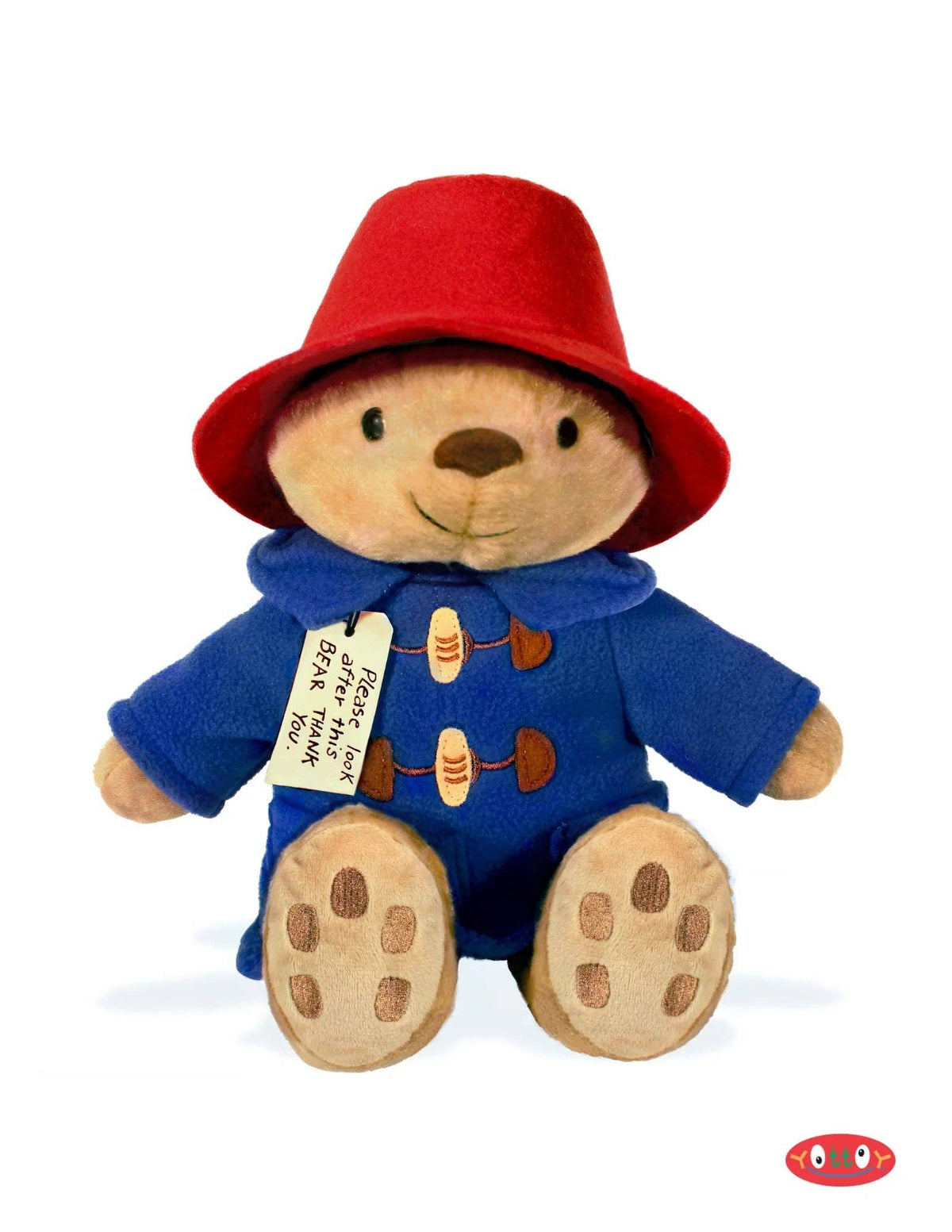 Plush toy bear in a red hat and blue coat with a tag on a white background