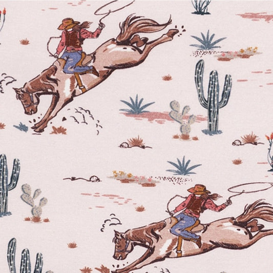 Pattern of cowgirls riding horses with desert scenery on a light pink background