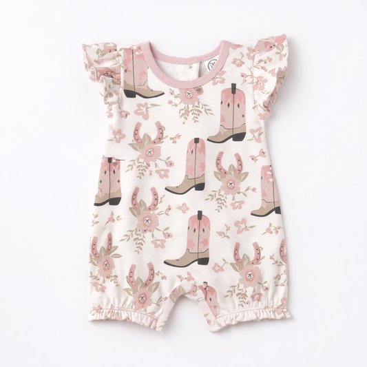 Baby romper with pink cowboy boot and horseshoe pattern on a white background
