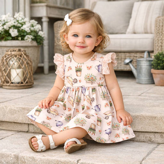 Young girl in a floral dress sitting on steps outdoors