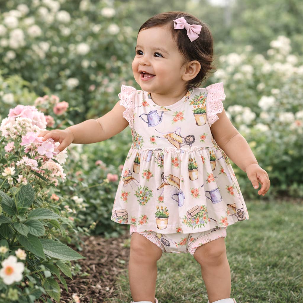 Child in a floral dress standing in a garden