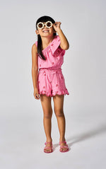Young girl wearing a pink outfit with sunglasses on a white background