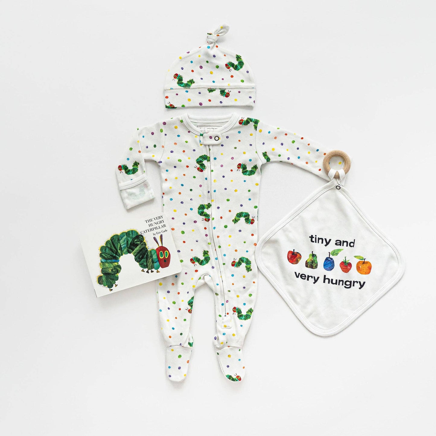 Baby outfit set with onesie, hat, and teether featuring 'The Very Hungry Caterpillar' design on a white background.