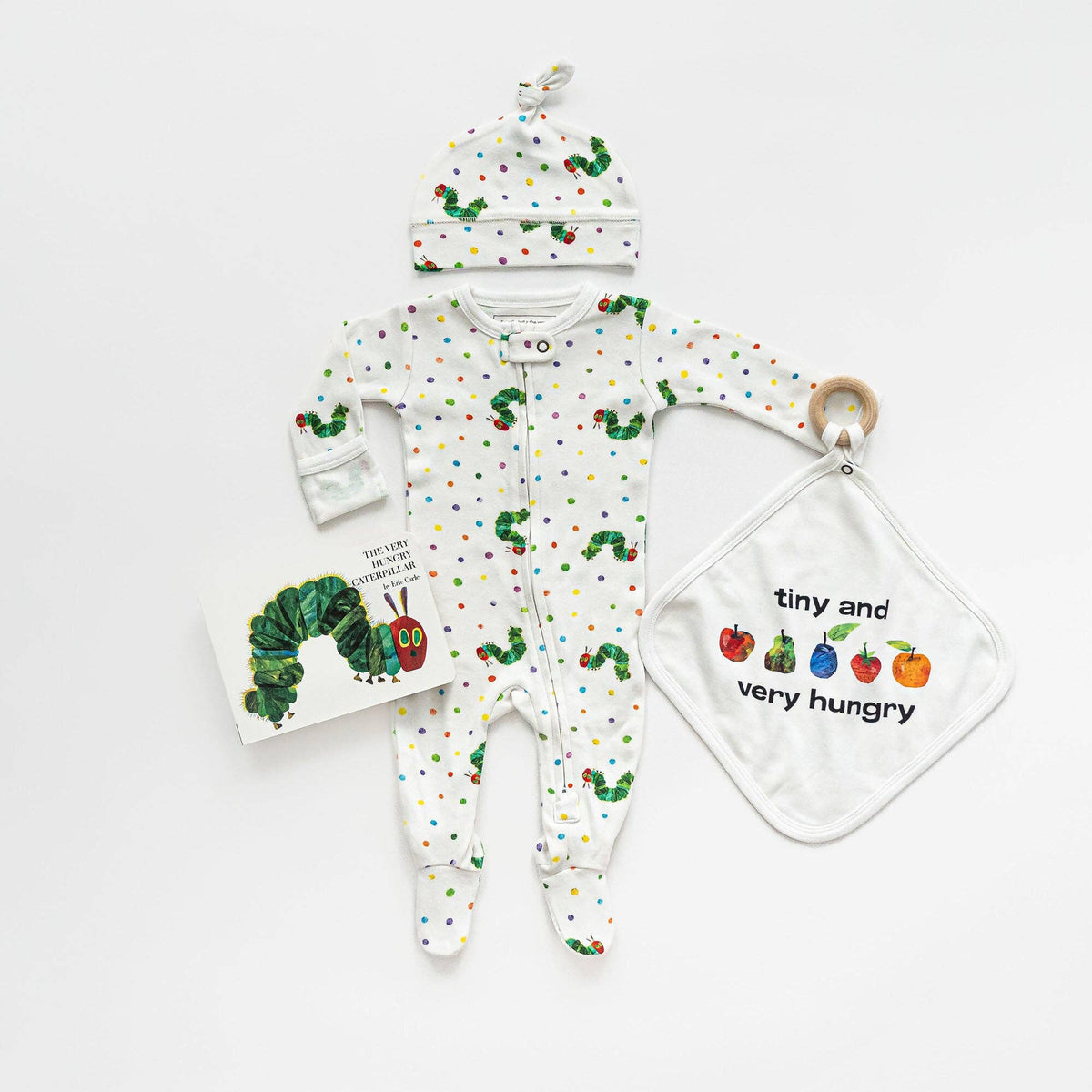 Baby outfit set with onesie, hat, and teether featuring 'The Very Hungry Caterpillar' design on a white background.