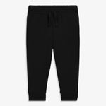 A pair of black organic baby pants with a waistband and decorative drawstring.