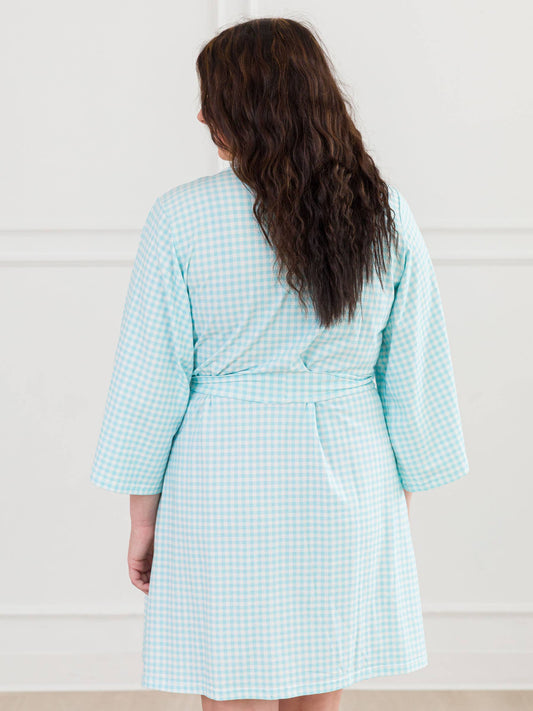 back of Person wearing a light blue checkered rob against a white background