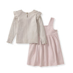 Back of beige long-sleeve top and pink dress on a white background