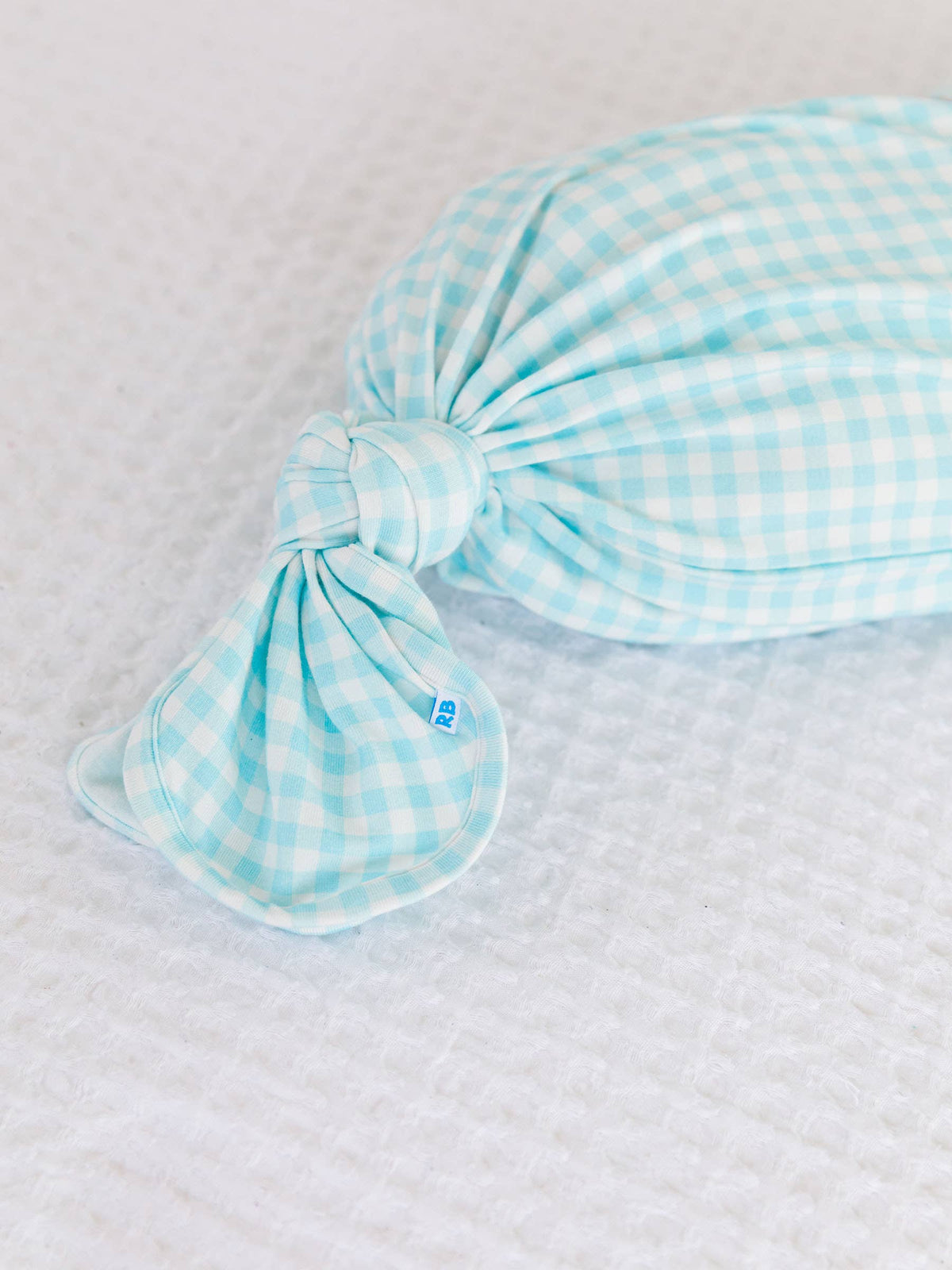 blue and white checkered baby wrap on a textured surface