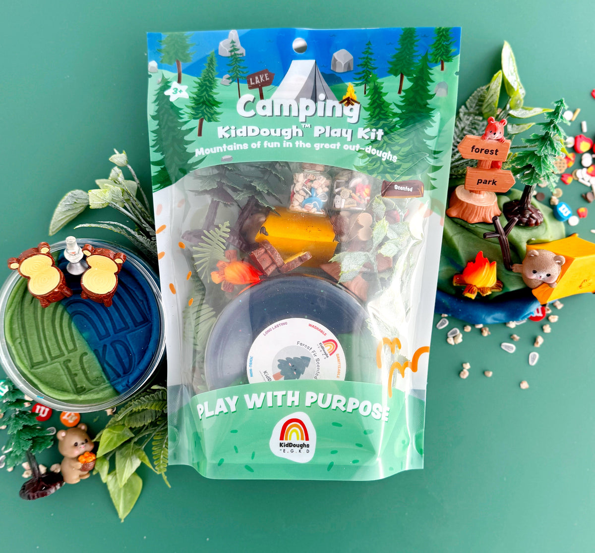 Camping-themed KidDough play kit with play dough and accessories on a green background