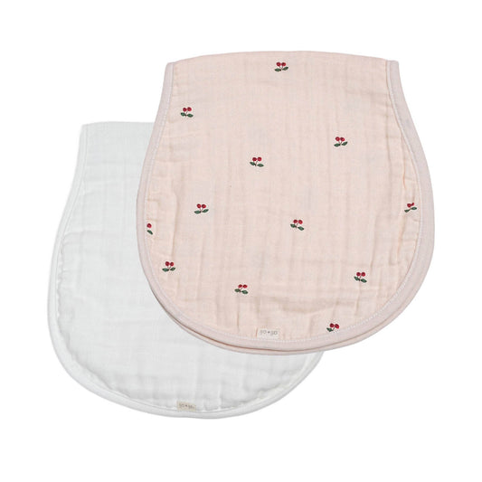 Two baby bur cloths, one pink with cherry pattern and one white, on a white background.