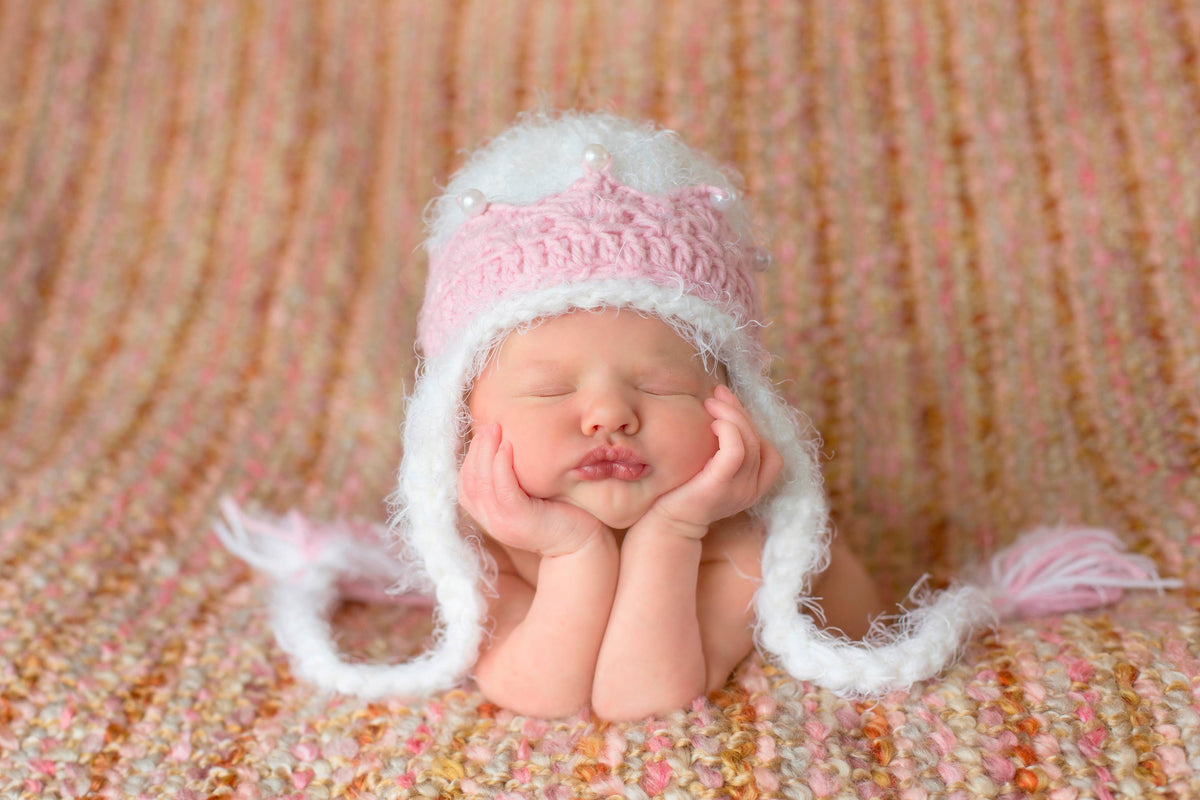 cute newborn baby first photo in pink and white princess hat