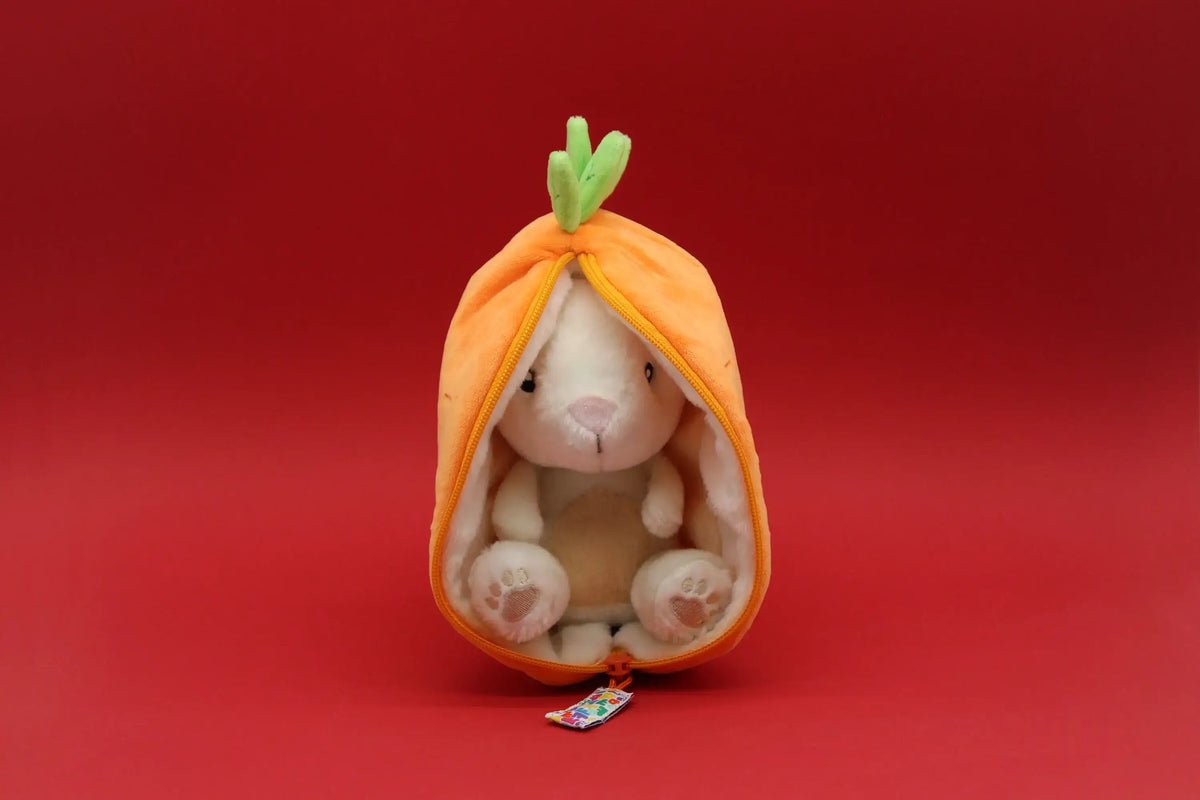 Plush toy rabbit inside a carrot-shaped pouch on a red background