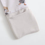 Folded baby romper with cartoon penguin design on a light gray background