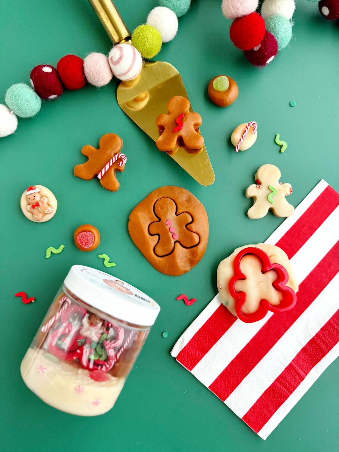 Decorative gingerbread-themed items on a green background with a jar of cookies.