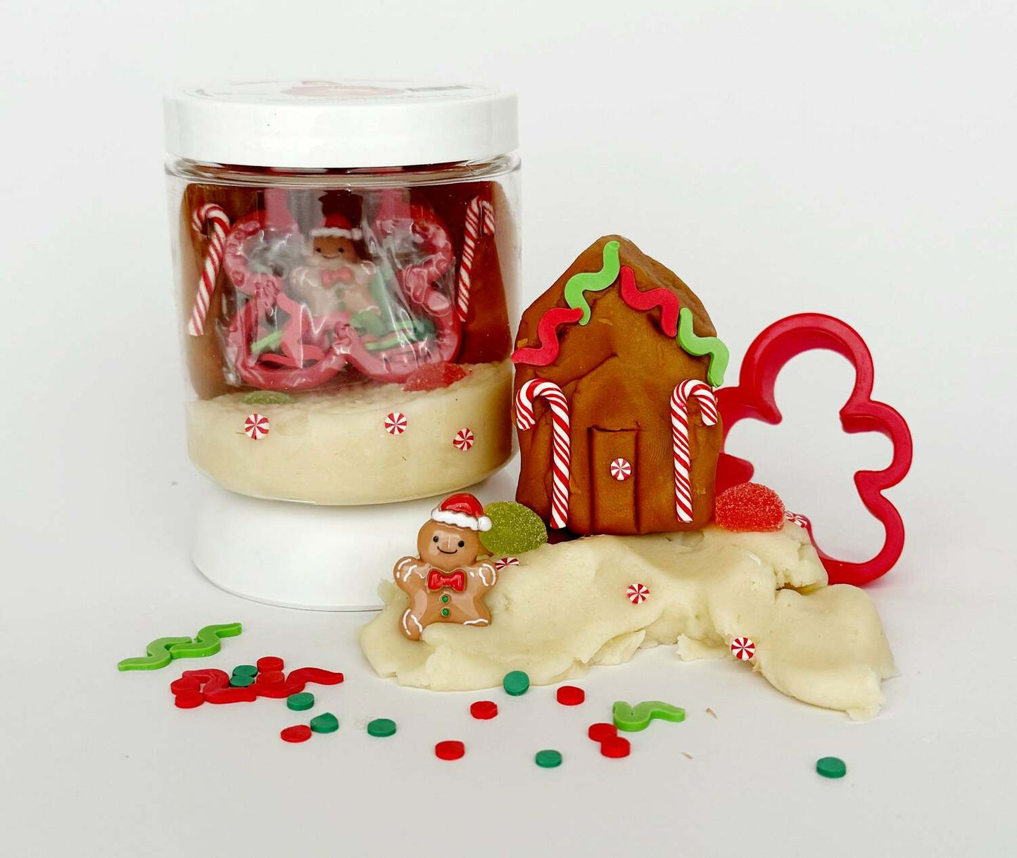 Play dough set with gingerbread house, candy cane, and cookie cutter on a white background