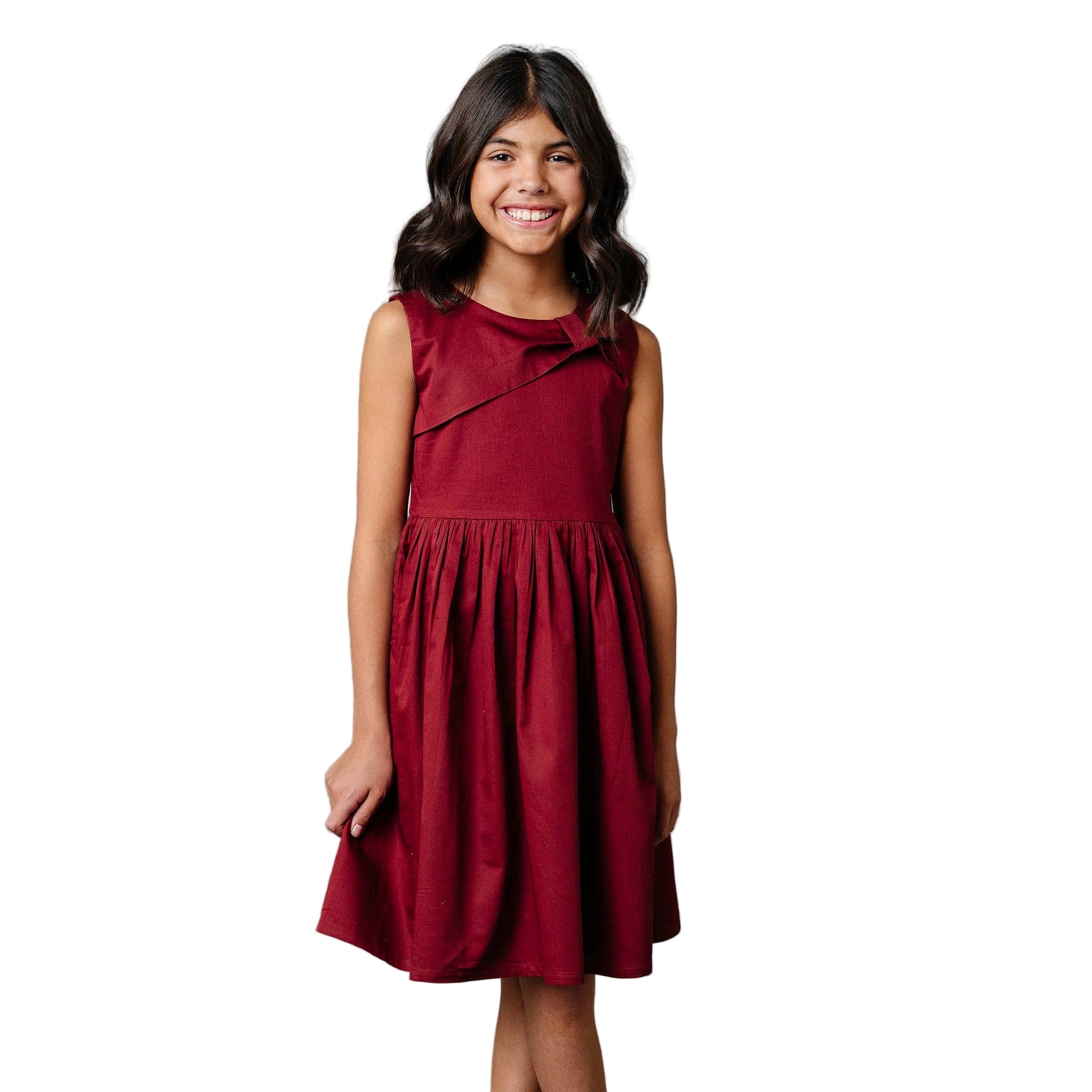 Young girl wearing a red dress against a white background