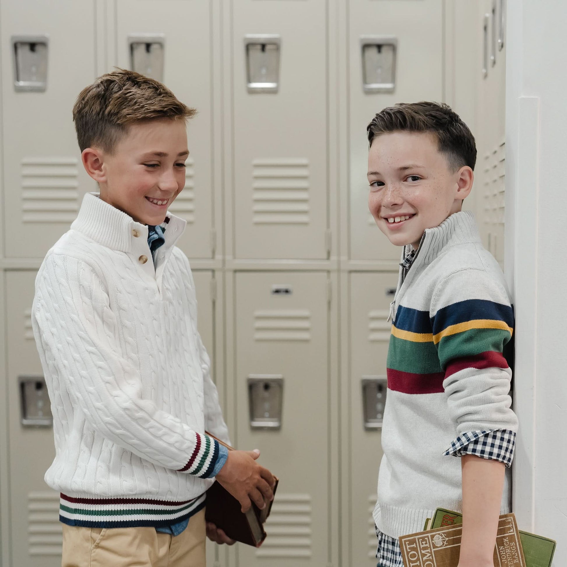 Two boys standing in front of lockers, wearing patterned sweaters.
