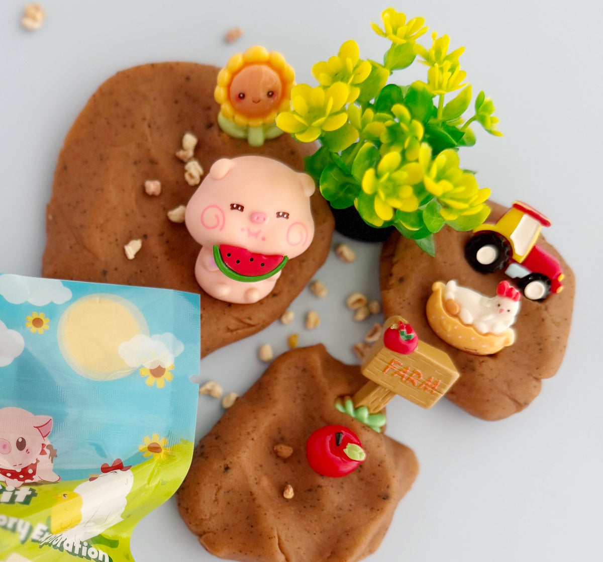 Dough with animal figures and a small plant on a white background