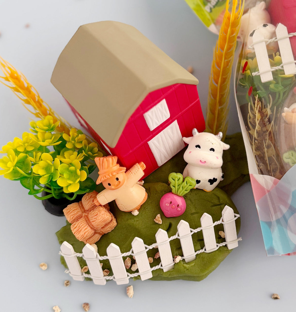 Playset with a barn, animals, and plants on a white background