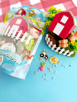 Toy farm set with a red barn, green grass, and small figures on a blue background.