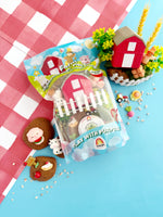 Playset packaging with farm-themed toys on a checkered tablecloth