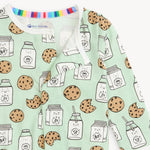 baby footie with cookie and milk pattern on a light green background