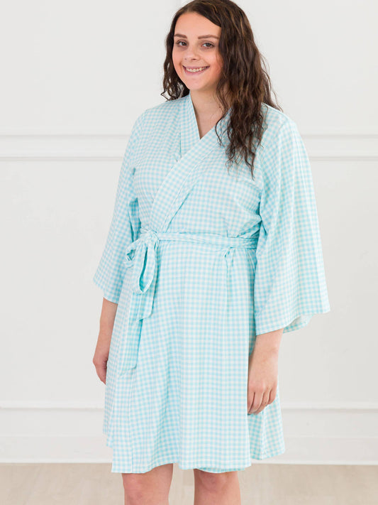 Woman wearing a light blue checkered robe against a white background