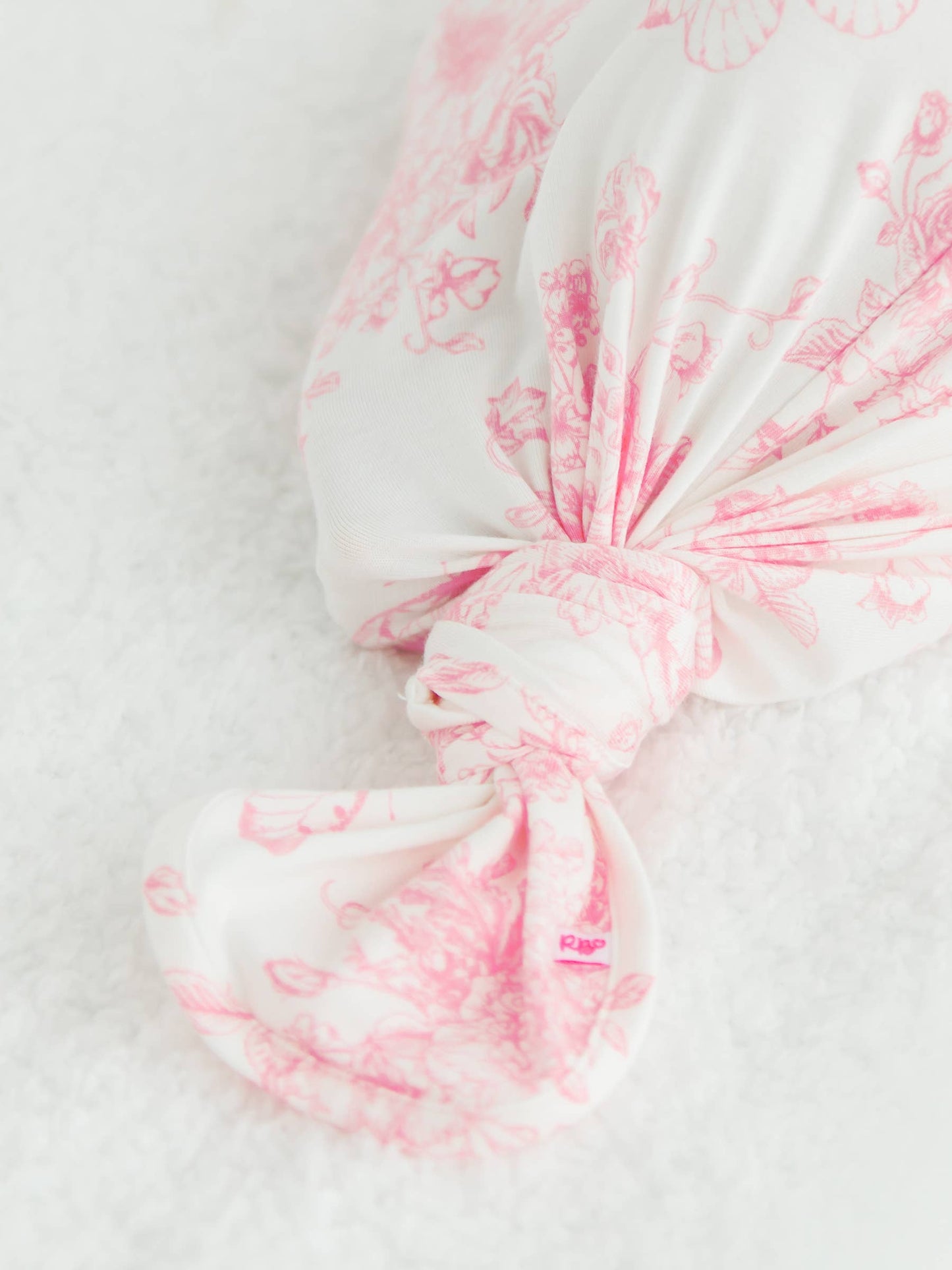 Pink and white toile gown knot on a white background