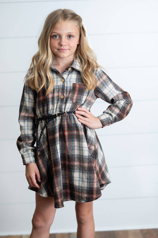 Young girl wearing a plaid dress against a white background