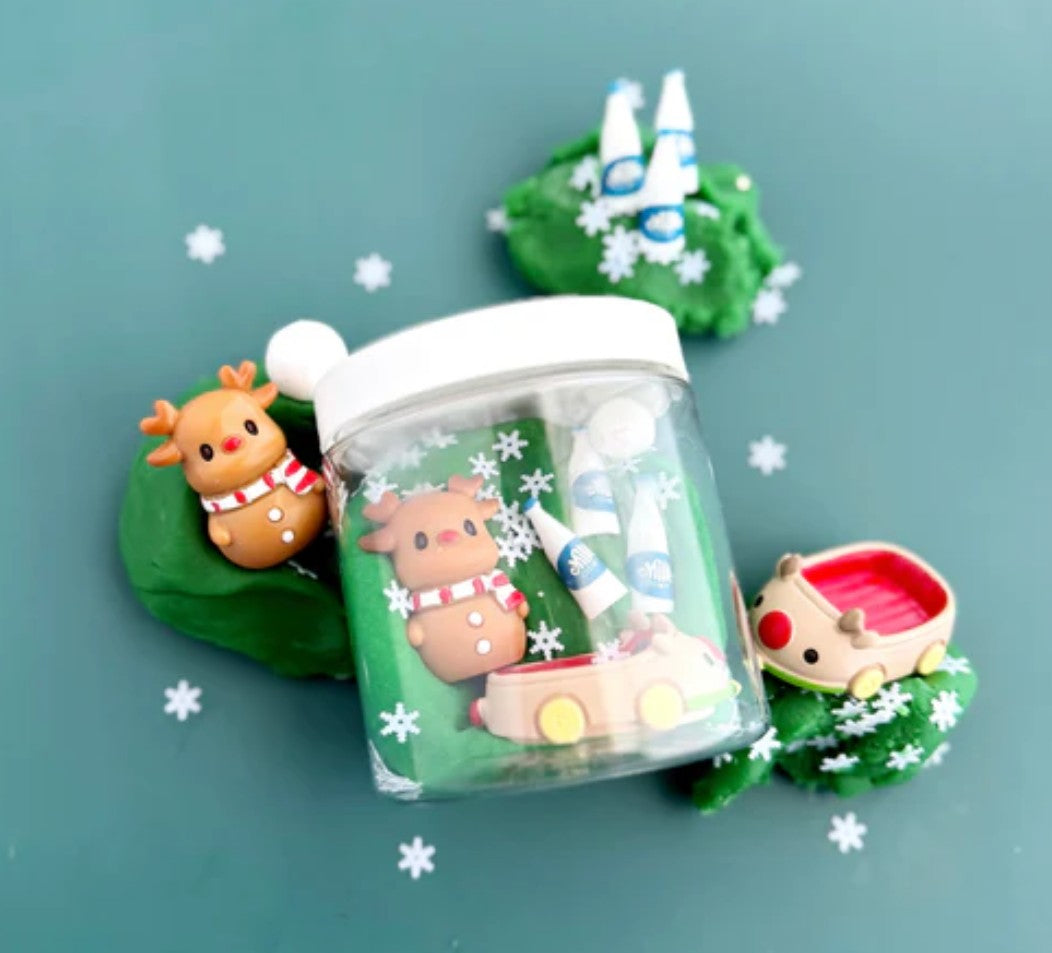 Small glass jar with Christmas-themed figurines on a green background
