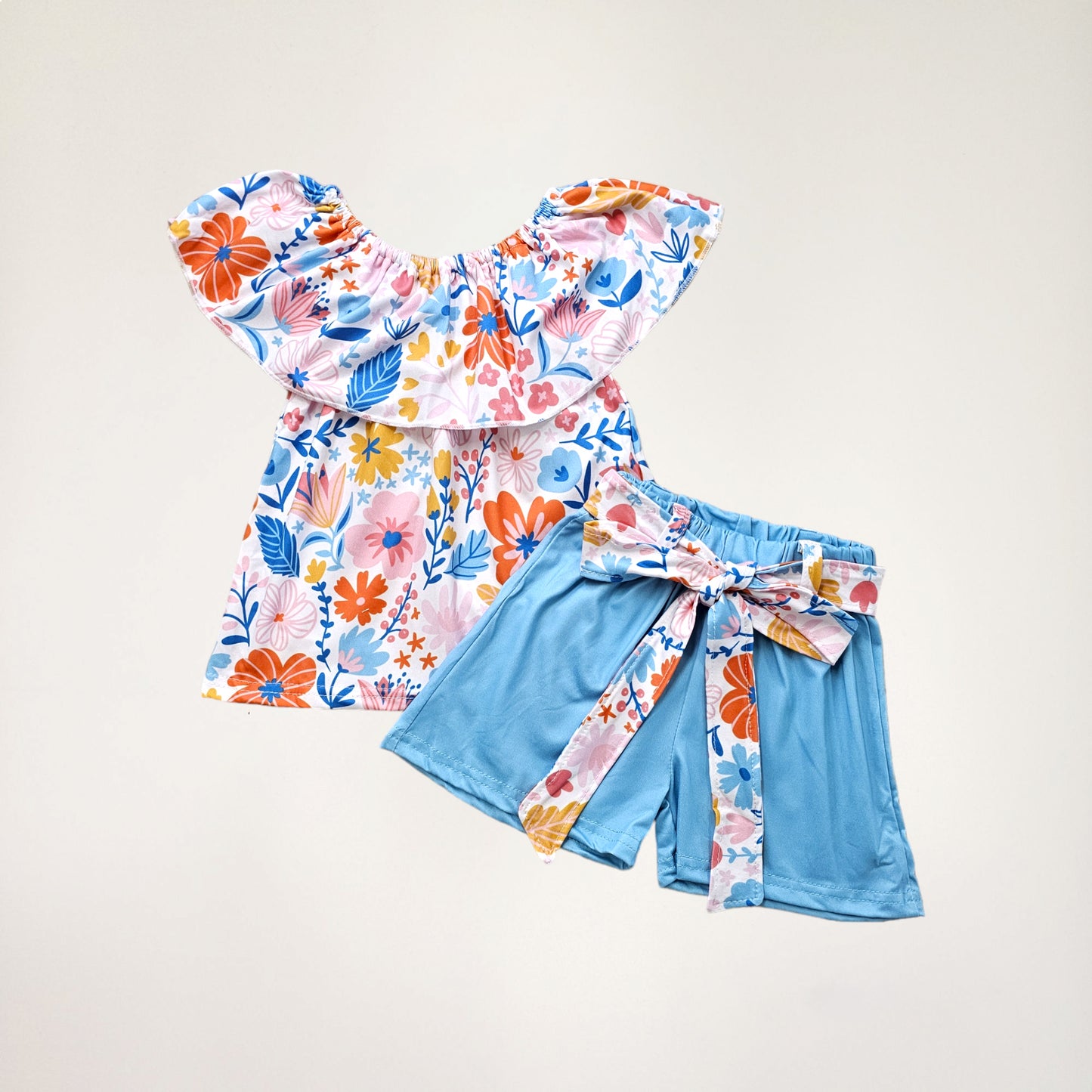 A boatneck floral short set with matching shorts and a tie belt