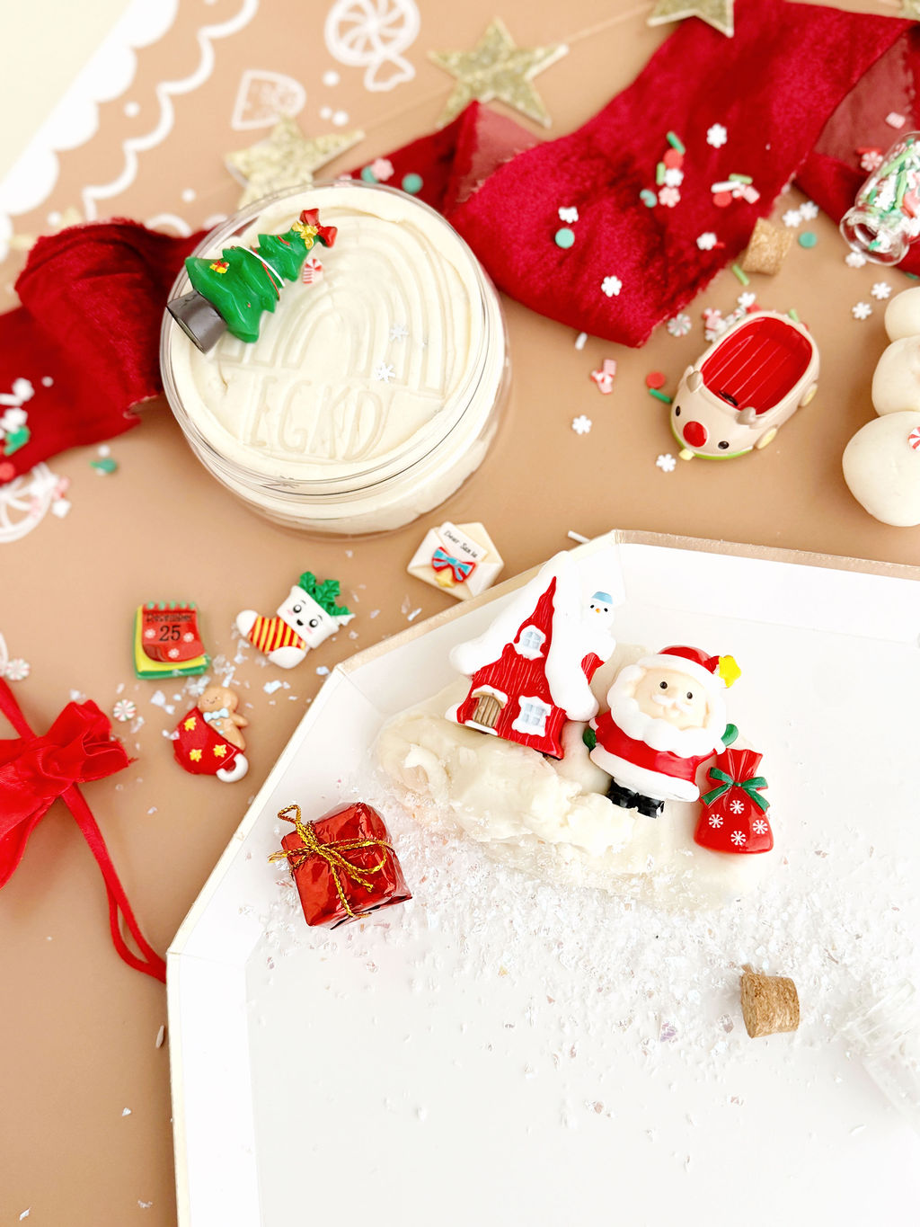 Decorative Christmas items including a Santa Claus figure, gift box, and snowman on a brown surface.
