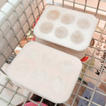 Two white square freezer containers with lids sitting in the freezer