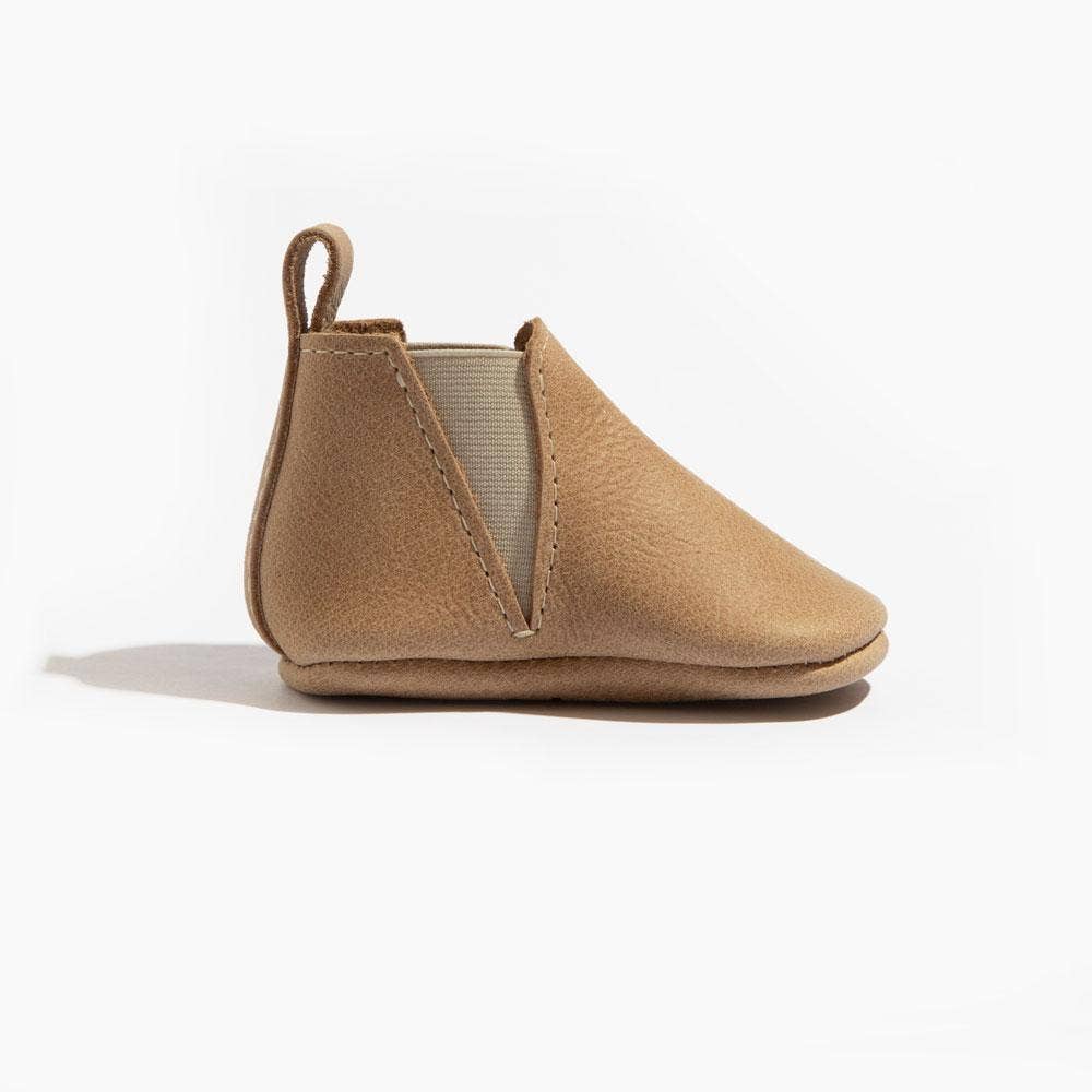 Tan baby shoe on a white background