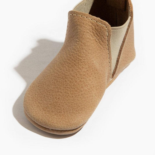 Tan baby shoe on a white background
