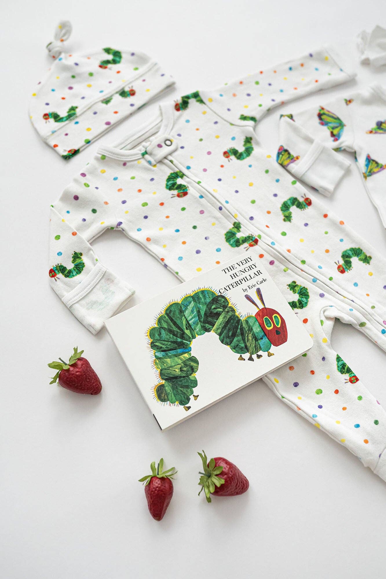 Baby clothing set with 'The Very Hungry Caterpillar' book on a white background